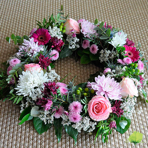 Corona floral en blanco, rosa y fucsia